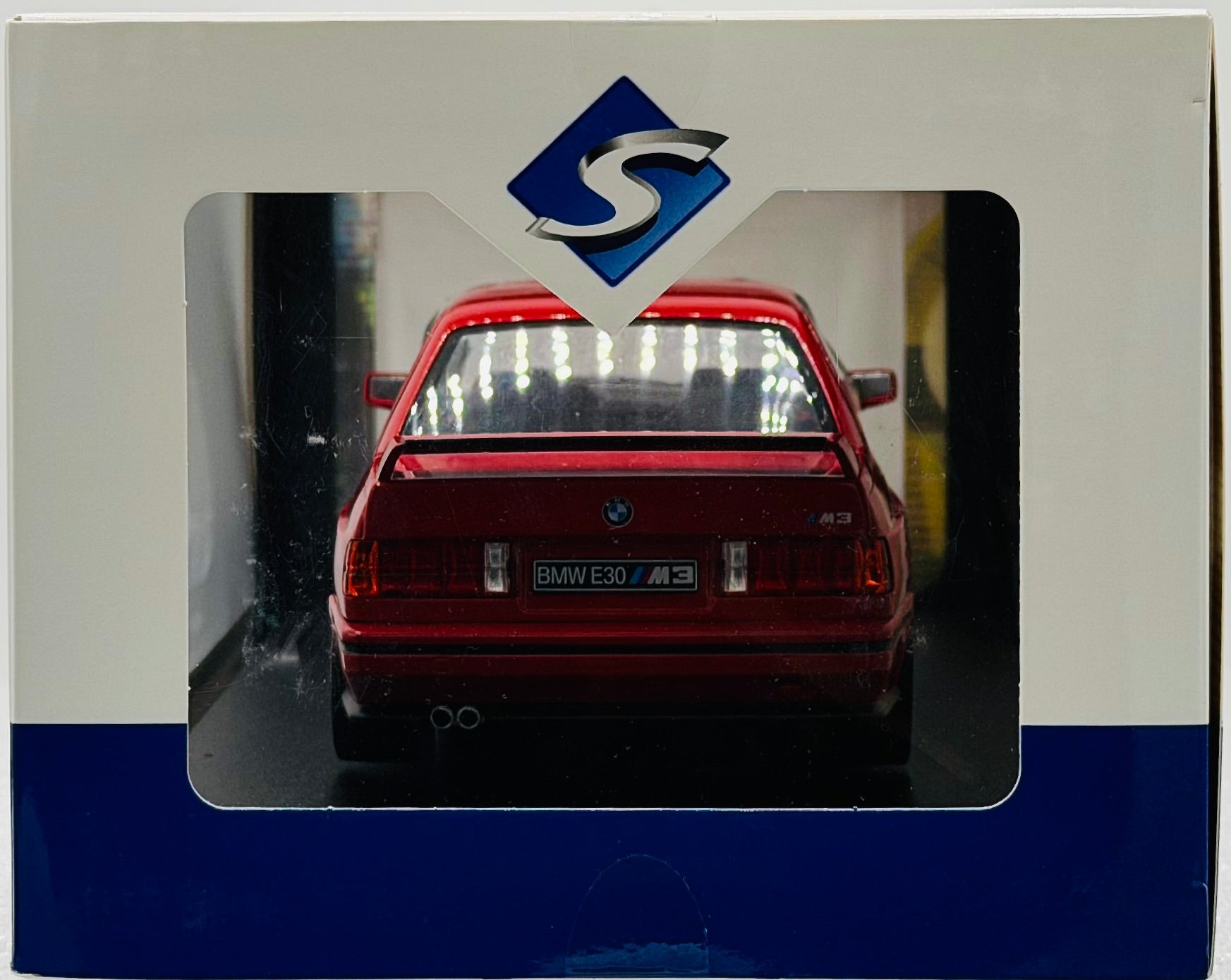 Model car in a display case with a logo above it