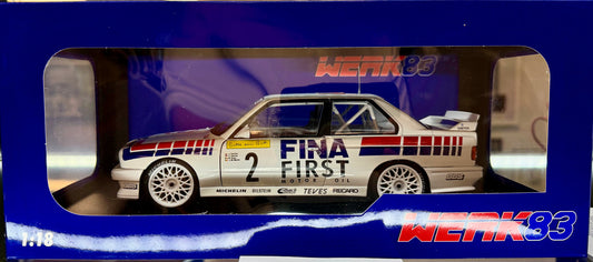 Model car in a blue display case with 'Fina First' branding.