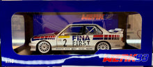Load image into Gallery viewer, Model car in a blue display case with 'Fina First' branding.