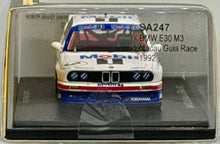 Load image into Gallery viewer, Model car of a BMW E30 M3 in a clear display case with branding and text.